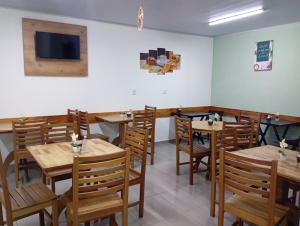 a dining room with wooden tables and chairs at Pousada Villa do Mar in Penha