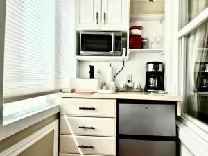a kitchen with white cabinets and a microwave at Barkerhouse 2# unit-heart of oldtown in Niagara-on-the-Lake