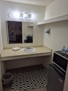 a man taking a picture of a bathroom with a sink at 66 Motel in Holbrook +46 photos