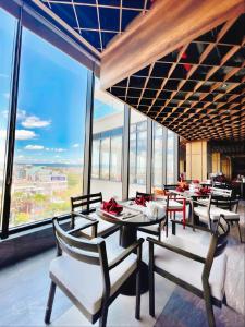 a restaurant with tables and chairs and large windows at Blue View Apec Tuy Hoa in Tuy Hoa