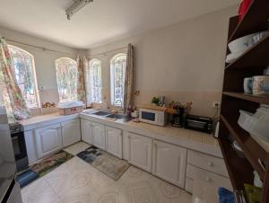 a kitchen with a sink and a microwave at Beachfront 4-Bedroom Villa with Rooftop Sunset Terrace in Flic-en-Flac