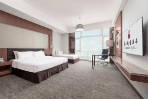 a hotel room with a large bed and a desk at Vanburgh Hotel Guangzhou in Guangzhou
