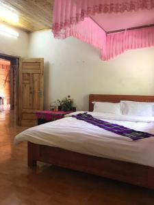 a bedroom with a large bed with a pink ceiling at My's Hmong House in Tả Van +32 photos