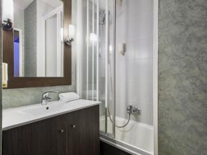 a bathroom with a shower and a sink and a mirror at Aparthotel Adagio Access Bordeaux Rodesse in Bordeaux +30 photos