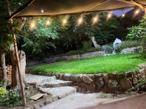 a garden at night with a stone wall and lights at HOSPEDAJE don VICTOR in Chancayllo +20 photos