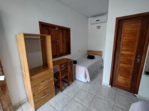a bedroom with a bed and a wooden dresser and a bed sidx sidx sidx at Pousada Chale Joana in Alter do Chao