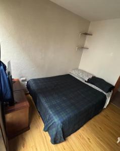 a bedroom with a bed and a tv in a room at Or mini habitación in Cuenca
