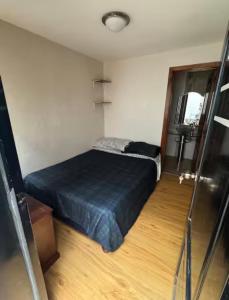 a bedroom with a bed with a blue comforter at Or mini habitación in Cuenca