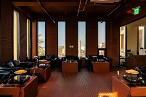 a lobby with couches and tables and windows at 콘스트호텔 in Hyŏpchae-ri
