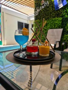 a table with two drinks on a glass table at Hotel Sueños in San Salvador