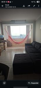 a living room with a couch and a window with a hammock at Mom Blanc Flat Service in São Luís