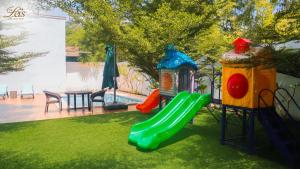 a playground with a slide in a yard at The Lei's Hotel and Beach Resort in Mercedes