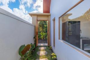 an external view of a house with a pathway leading to a door at Rupa Arya Villa in Ubud
