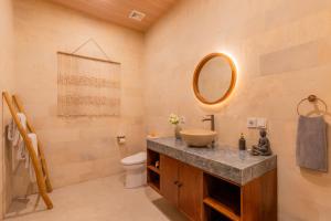 a bathroom with a sink and a toilet and a mirror at Rupa Arya Villa in Ubud +22 photos