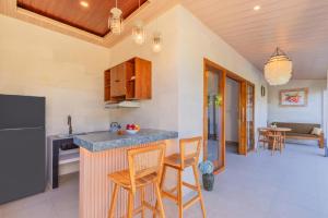 a kitchen with a counter and chairs in a room at Rupa Arya Villa in Ubud