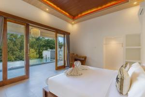 a bedroom with a bed and a view of a pool at Rupa Arya Villa in Ubud