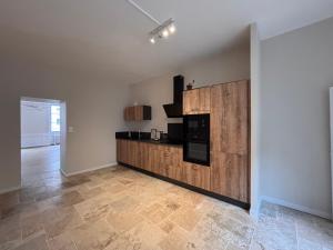 a kitchen with a counter with a microwave and a stove at Maison Léon in Dole