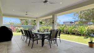 a dining room table and chairs on a patio at Pollys in Callala Bay +15 photos