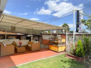 a patio with awning and chairs and tables at Hostería Real Parque Tababela in Tababela