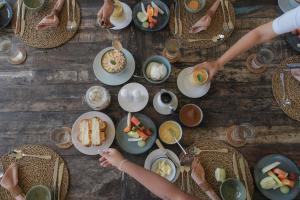 a group of people sitting at a table with plates of food at Rukgala Retreat in Digana