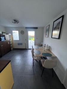 a dining room with a table and chairs and a kitchen at Victoria II Parking GRATUIT in Boussu