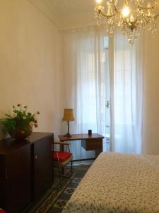 ローマにあるA casa di Fiammaのベッドルーム1室(ベッド1台、デスク、シャンデリア付)