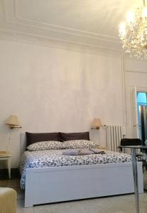 ローマにあるA casa di Fiammaの白い部屋の白いベッド(シャンデリア付)