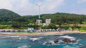 a view of a beach with a wind turbine at Pohang Sausalito by B-Class Pool Villa in Pohang