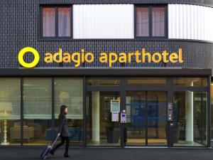 a woman walking in front of an apple appartment at Aparthotel Adagio Access Le Havre Les Docks in Le Havre