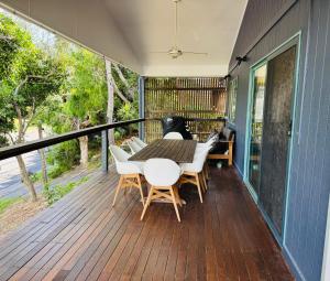 a patio with a table and chairs on a deck at Tuckeroo + sleeps 10 + central in Point Lookout