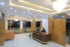 a man sitting at a desk in a lobby at Supreme Sapphire Kufri in Fagu