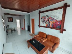 a living room with a couch and a painting of a horse at Just Inn in Semarang