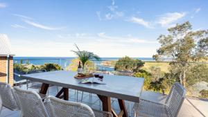 a dining table on a balcony with a view of the ocean at Halcyon in Kiama +25 photos