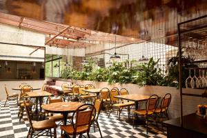 a restaurant with tables and chairs on a checkered floor at Hotel Harry, an Ascend Collection Hotel in Sydney