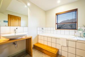 a bathroom with a sink and a tub and a window at Hidden Lodge Queenstown in Queenstown +60 photos