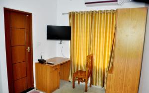 a room with a desk and a yellow curtain at Marari A R Residency in Mararikulam