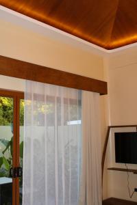 a living room with a window and a brown ceiling at Mawari Sanctuary Villa El Nido in El Nido