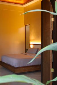 a bedroom with a bed with a mirror at Mawari Sanctuary Villa El Nido in El Nido