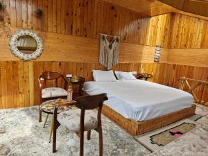a bedroom with a bed and a table and chairs at Avina Heaven in Banjār