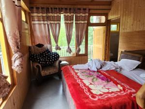 a bedroom with a bed and a chair and a window at Avina Heaven in Banjār +6 photos