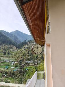 a clock hanging from the side of a balcony with a view at Avina Heaven in Banjār