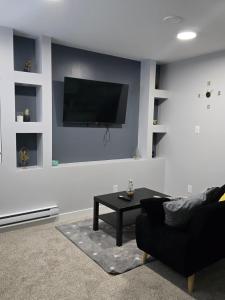 a living room with a couch and a tv on a wall at Basement suite in Winnipeg in Winnipeg +5 photos
