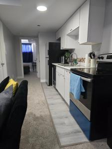 a kitchen with white cabinets and a black refrigerator at Basement suite in Winnipeg in Winnipeg