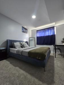 a bedroom with a bed with a window and a desk at Basement suite in Winnipeg in Winnipeg