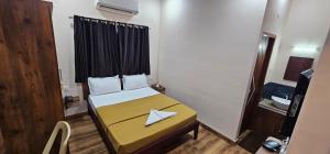 a small room with a bed with a paper boat on it at Tamil Arangam in Kumbakonam