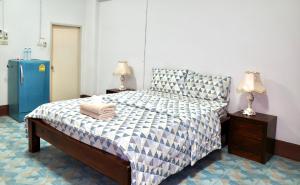 a bedroom with a bed and a blue refrigerator at Chanathinat Place in Udon Thani