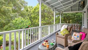 a porch with chairs and a table and a bird at Lilly Pilly Arthouse in Stanwell Park