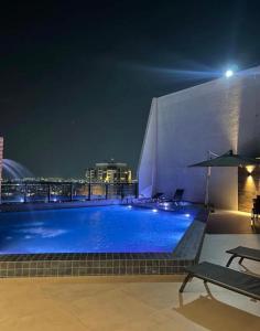 a swimming pool on the roof of a building at night at Flat Aconchegante Hotel Intercity Manaus in Manaus