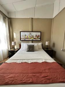 a large bed in a room with two tables and two lamps at Villa Gabriela, Casa Tucan in Liberia