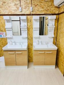 a bathroom with two sinks and a mirror at ゲストハウス元町 in Ise